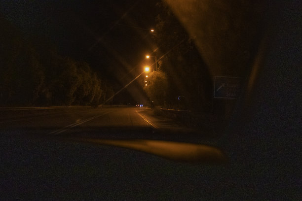 黑夜透过挡风玻璃照亮道路的一辆汽车，水平行驶图片下载