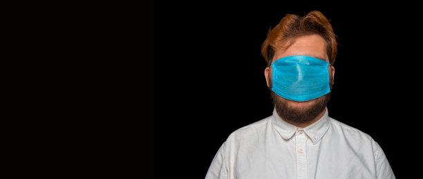 社会盲症的概念，现在的男性肖像摄影与面罩上的眼睛，全景格式与黑色背景为您的广告文本图片下载