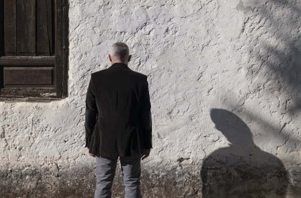 白色墙，木窗，西装男后视图。拍摄于西班牙马德里的新巴兹坦图片下载