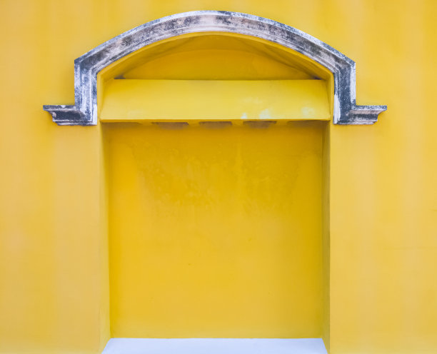 黄色墙壁上的旧混凝土通风口。图片下载