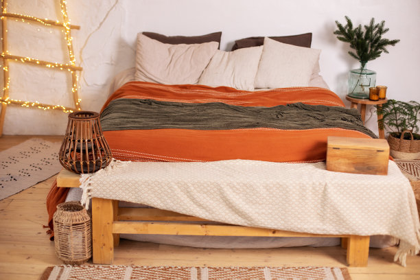 斯堪的纳维亚卧室内室。现代乡村房间装饰新年装饰圣诞树，舒适的床和花瓶与树枝松树。Hygge圣诞装饰。舒适的家。图片下载