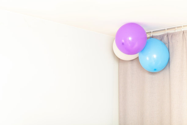 天花板附近的墙上挂着三个喜庆的气球，抽象出普遍的节日生日背景，为文字复制空间，无人。在房间里的家庭季节的房子聚会背景，庆祝图片下载