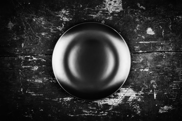 空的黑色盘子在木制古董黑色grunge背景俯视图，黑白照片图片下载