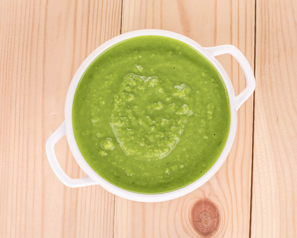 白碗里盛着绿奶油汤。图片下载