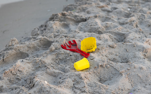 孩子们在海边的沙滩上玩玩具图片下载