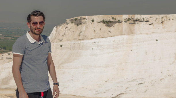 有胡子的年轻男子的侧面照片，手放在膝盖上的白色自然背景图片下载