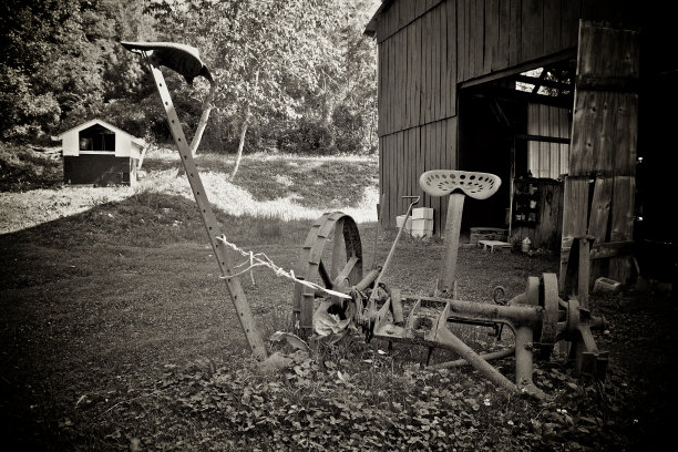 谷仓外生锈的旧干草镰刀。图片下载
