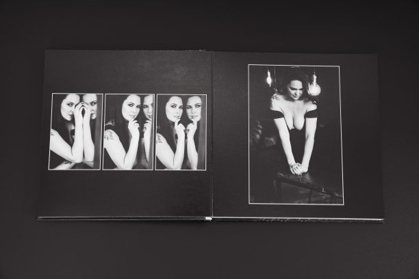 打开一本照片簿，从一个有魅力的女人在一个黑色背景的照片拍摄。图片下载