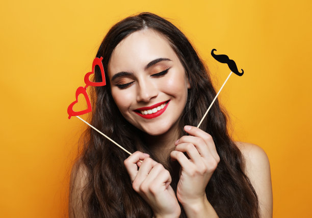 顽皮的年轻女子准备派对在黄色背景图片下载