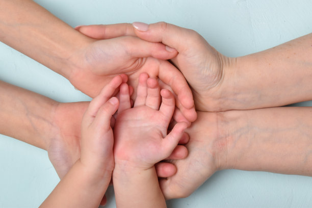 母亲张开的手掌，孩子们张开的手掌躺在那里，那里是一片空白。家庭和团结的旗帜。图片下载