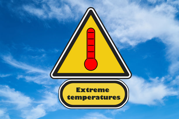 道路三角形黄色标志，上面有红色温度计和极端温度的文字。背景是天空。气候变化的概念，全球变暖。图片下载
