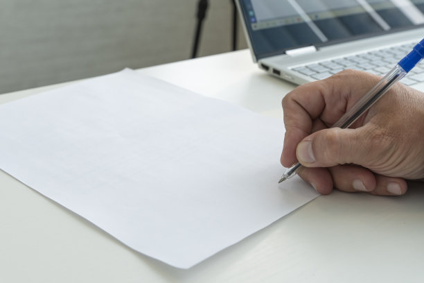 手拿笔在一张空白的纸文件上签名。在明亮的阳光下，一名男子用特写笔填写一张白纸。图片下载