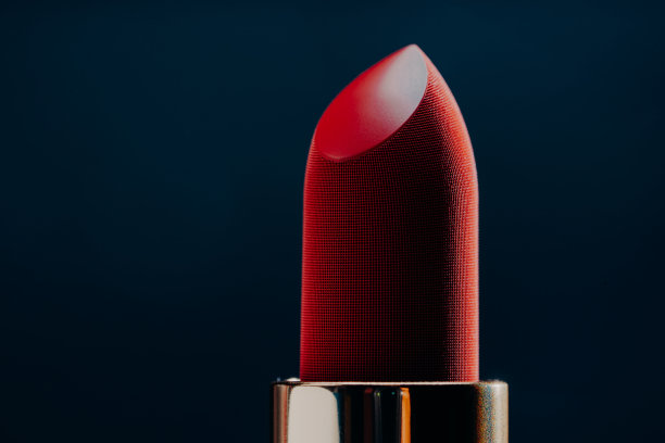 宏观纹理的活力唇膏孤立在蓝色背景。美容品牌展示或广告。时尚概念，力士美容业，化妆品复制空间图片下载