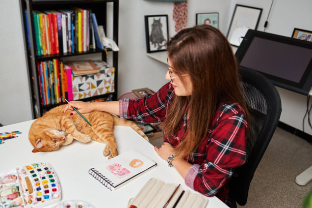 一位妇女在远程工作时抚摸她的猫图片下载