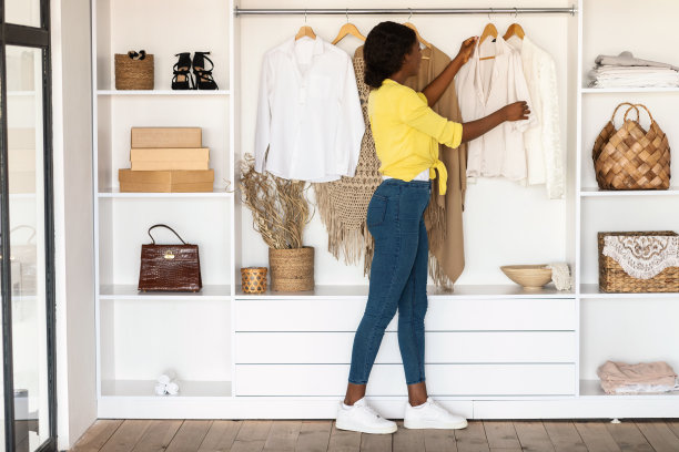 非洲年轻女士在衣柜里挑选衣服图片下载
