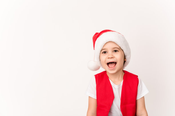 美丽快乐笑男孩的肖像，红色圣诞老人的帽子孤立在白色的背景。五岁的欧洲小孩。副本的空间。圣诞节的模型设计。等待幸福的概念。新的一年图片下载
