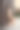 高大时尚的女孩带着一个包在米色超大夹克和橙色裤子在砖墙背景图片下载