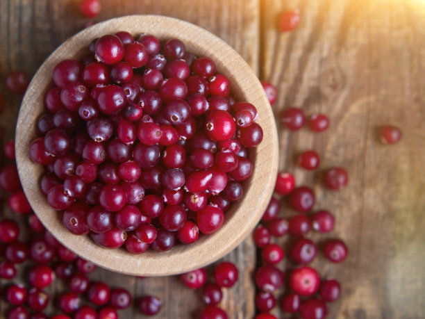 新鲜成熟的蔓越莓放在木碗里，放在质朴的桌面上。图片下载