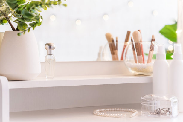 梳妆台上有镜子和化妆配件。自我保健。白色,柔和的室内图片下载