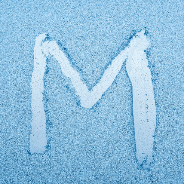在霜冻的冬天，玻璃上写着字母M图片下载