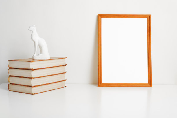 垂直人像框架模型与空白的品牌，图片，照片或文本。极简的室内模板，空框架，书堆和室内猫雕像图片下载