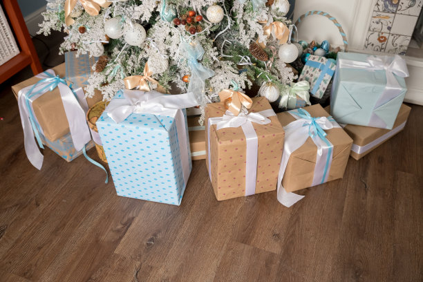 用手工装饰的不同圣诞礼物。传统的圣诞松树与节日装饰和堆积在木制地板上的礼物。神奇的夜晚。关闭，复制空间，内部。冬天的假期。图片下载