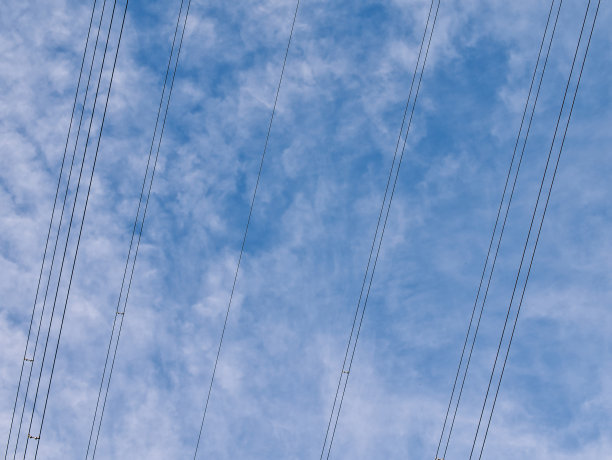 头顶上的高压输电电缆——英国国家电网的一部分——映衬着蓝天和白云。图片下载
