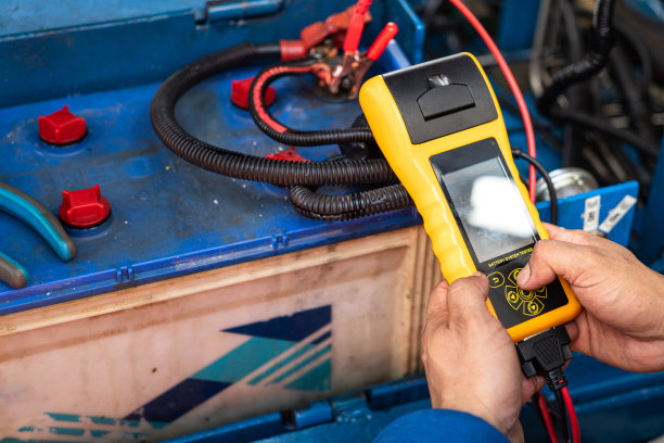 一个机械师正在测试汽车电池的电压。图片下载