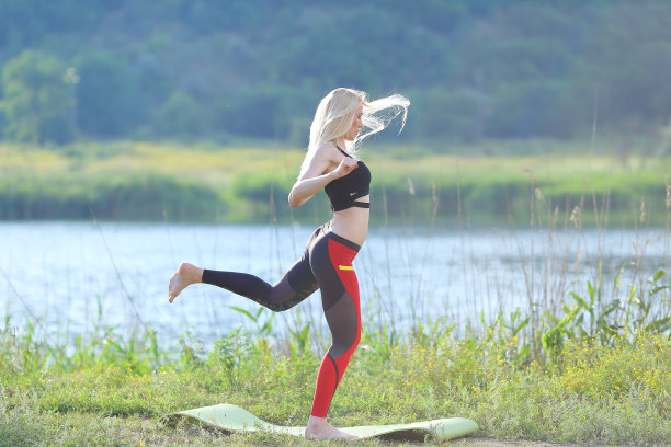 年轻美丽的女子下蹲显示结果压在腹部锻炼训练穿着上衣图片下载