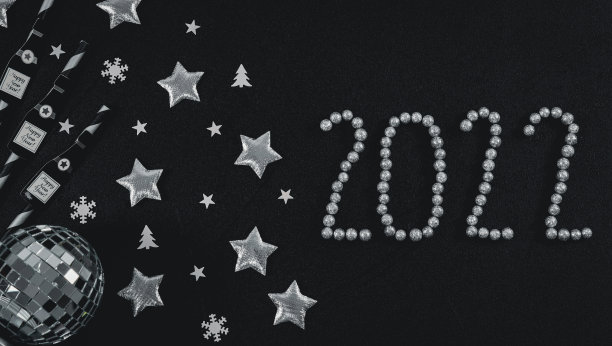 吸管上的纸香槟瓶，银色的星星，迪斯科球，雪球和黑色的2022号图片下载