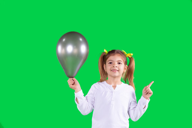 近距离拍摄一名身穿校服、一只手拿着灰色气球、另一只手举着食指、面带微笑的女学生。图片下载