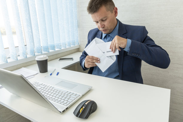 商人可以考虑在工作场所接收纸质信件或文件信息。商人带着信，信封打开图片下载