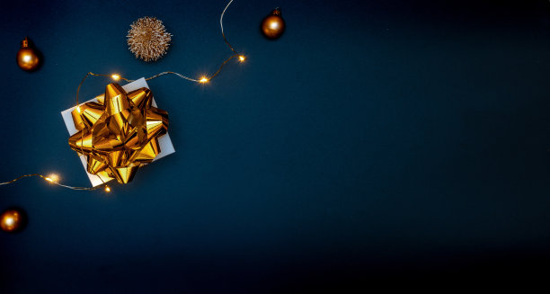 圣诞组成。白色礼品盒与金色的丝带，新年球和闪闪发光的灯花环在圣诞节组成在黑色背景贺卡。平铺，俯视图，复制空间。图片下载