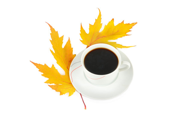 一杯咖啡和白色背景下的黄色枫叶。图片下载