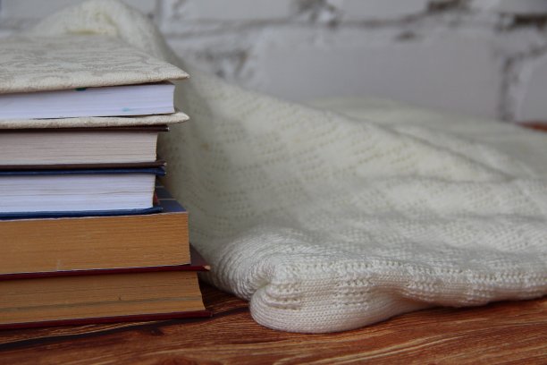 旁边有一堆书和一件舒适的毛衣图片下载