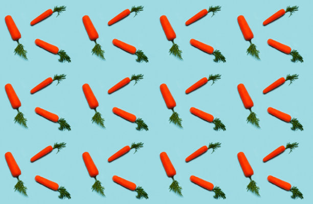蓝色背景上的胡萝卜图案。为复活节或包装纸设计。创意副本空间图片下载