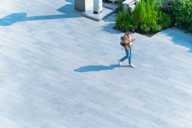 空中俯视图，戴着口罩的人走过地面黑色剪影的步行街，社会新常态生活概念，预防新冠疫情和空气污染。图片下载