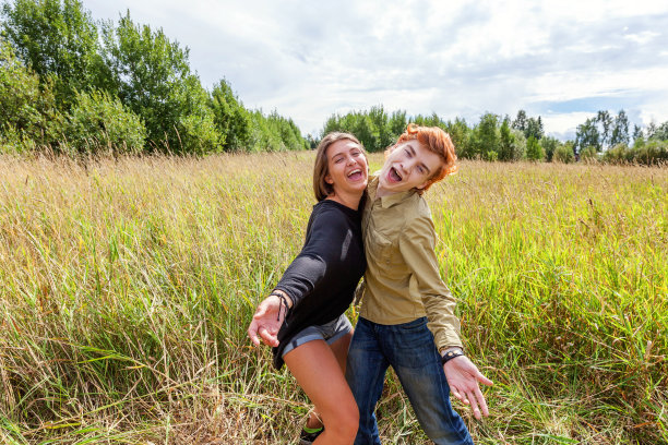 暑假假期快乐人概念。相爱的情侣一起在户外享受大自然的乐趣。快乐的年轻人跳舞拥抱他的女朋友。幸福的情侣在夏日的户外图片下载