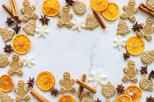 节日的圣诞节设计海报框架的形象，自制，形状的姜饼人和小饼干大理石效果的背景，肉桂棒，干桔子片，八角，圣诞节墙纸，复制空间图片下载