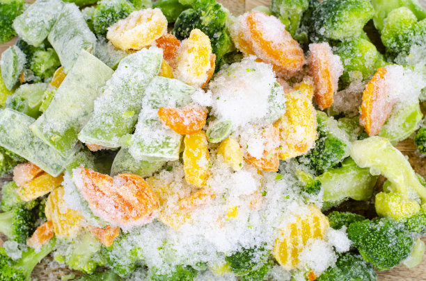 木质砧板上的冷冻生物蔬菜。工作室的照片。图片下载