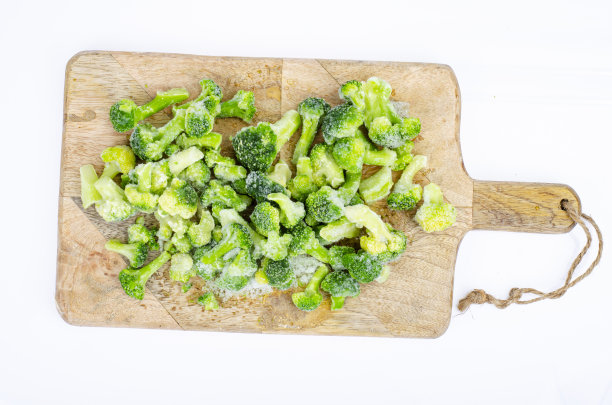 木质砧板上的冷冻生物蔬菜。工作室的照片。图片下载