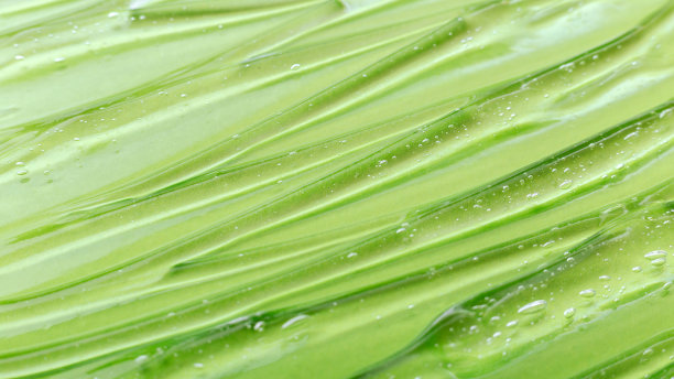 天然草本化妆品凝胶。血清绿色透明液体表面为颜色背景。皮肤护理健康美容。长网络横幅。图片下载