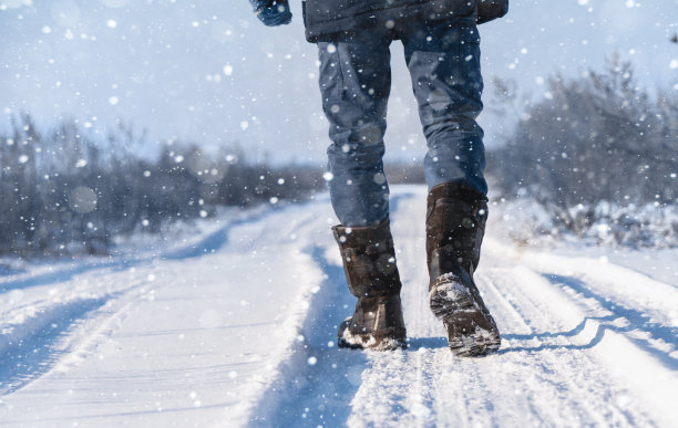 一个人走在下雪的路上。图片下载