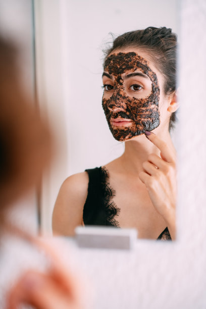 年轻女子在镜子前做面膜图片下载