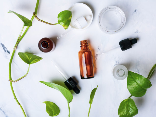 白色大理石背景上用于天然化妆品的玻璃瓶和罐子图片下载