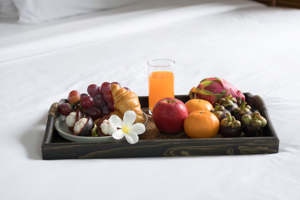 早餐，水果，羊角面包，橙汁，黑色木托盘，白色床单，健康食品概念图片下载