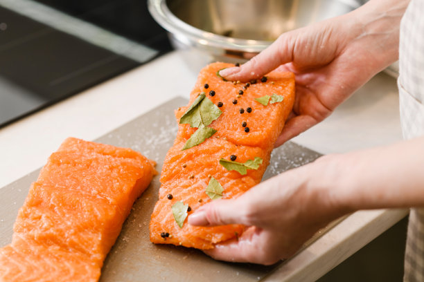 女人的手拿着红色的鱼片和香料图片下载