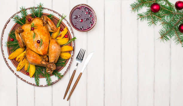 圣诞烤鸡与香料和草药在白色木制背景与复制空间。圣诞食品的概念。图片下载