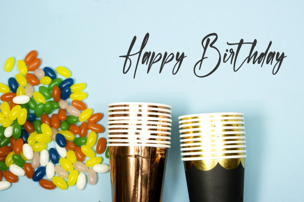 五彩糖豆糖果和一次性杯子，生日快乐概念图片下载