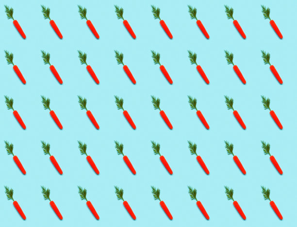 蓝色背景上的胡萝卜图案。为复活节或包装纸设计。创意副本空间图片下载